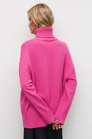 Oversized turtleneck knit sweater in vibrant hot pink with ribbed cuffs and hem.