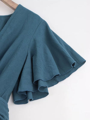 Haze blue cotton romper with flutter sleeves and tie waist detail.