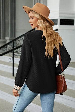 Black textured V-neck blouse with embroidered cuff detail