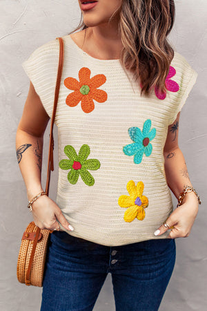 Tan crochet knit top with colorful floral appliqués and cap sleeves.