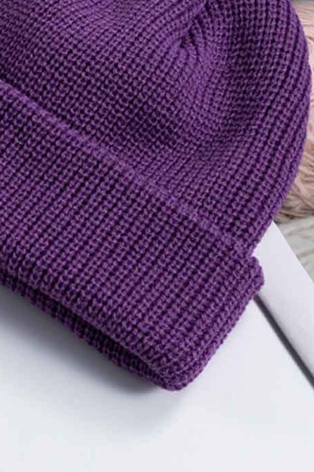 Purple ribbed knit beanie with a turn-up cuff.
