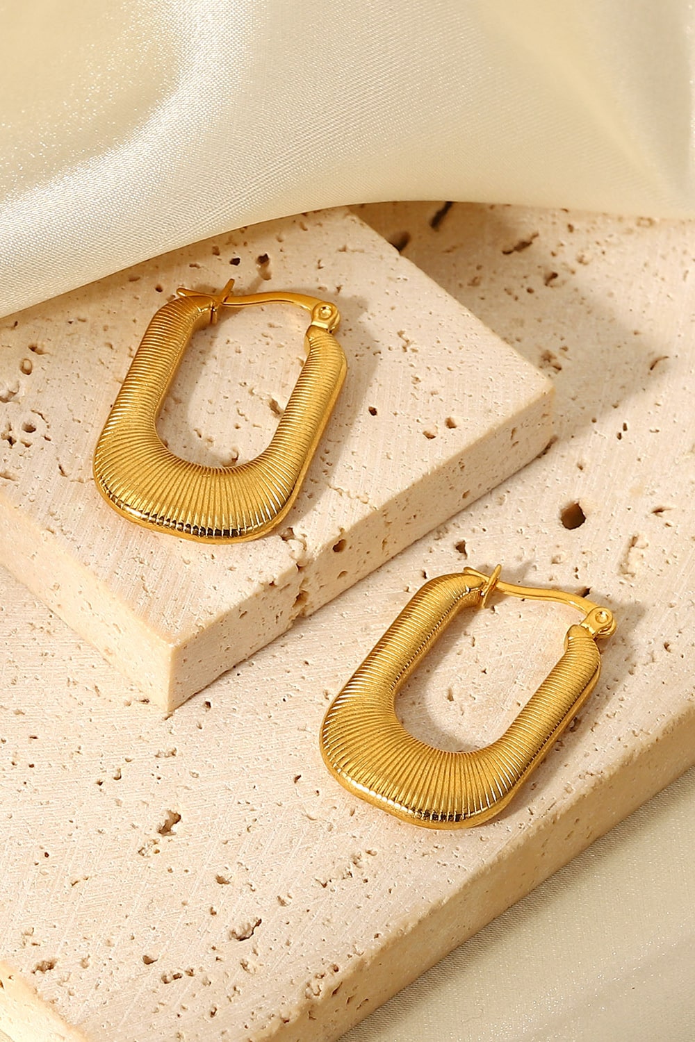 Textured gold rectangular hoop earrings with a ribbed surface detail.