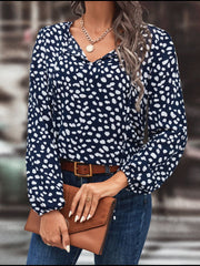 Cobalt blue blouse with white abstract spots, tie-neck, and long sleeves.