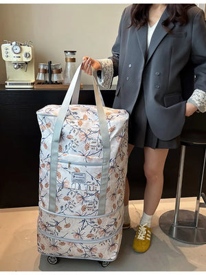 Charming floral rolling travel bag in white with a delicate botanical print and dual handles.
