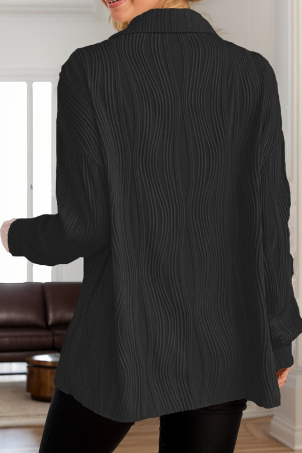Black oversized button-down shirt with textured wave pleats and a collar.
