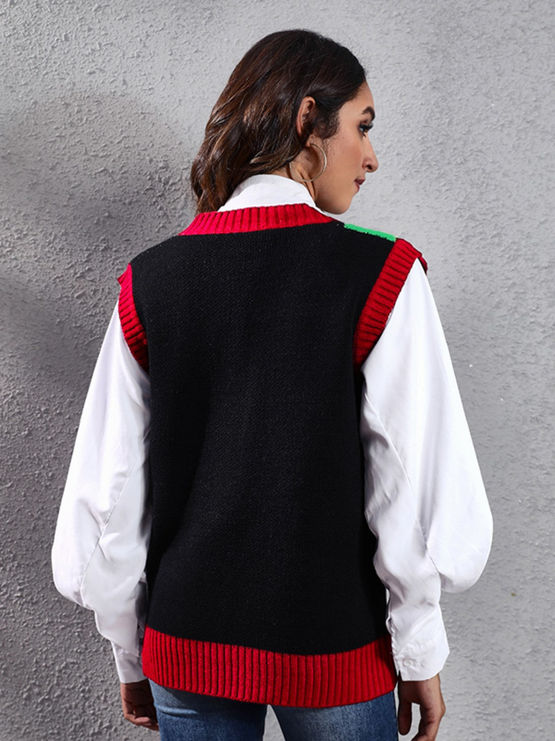 Black acrylic knit vest with red trim and subtle green detail on shoulder.