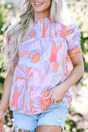 Psychedelic smocked puff sleeve blouse in multicolor with a high neckline and ruched sleeves.