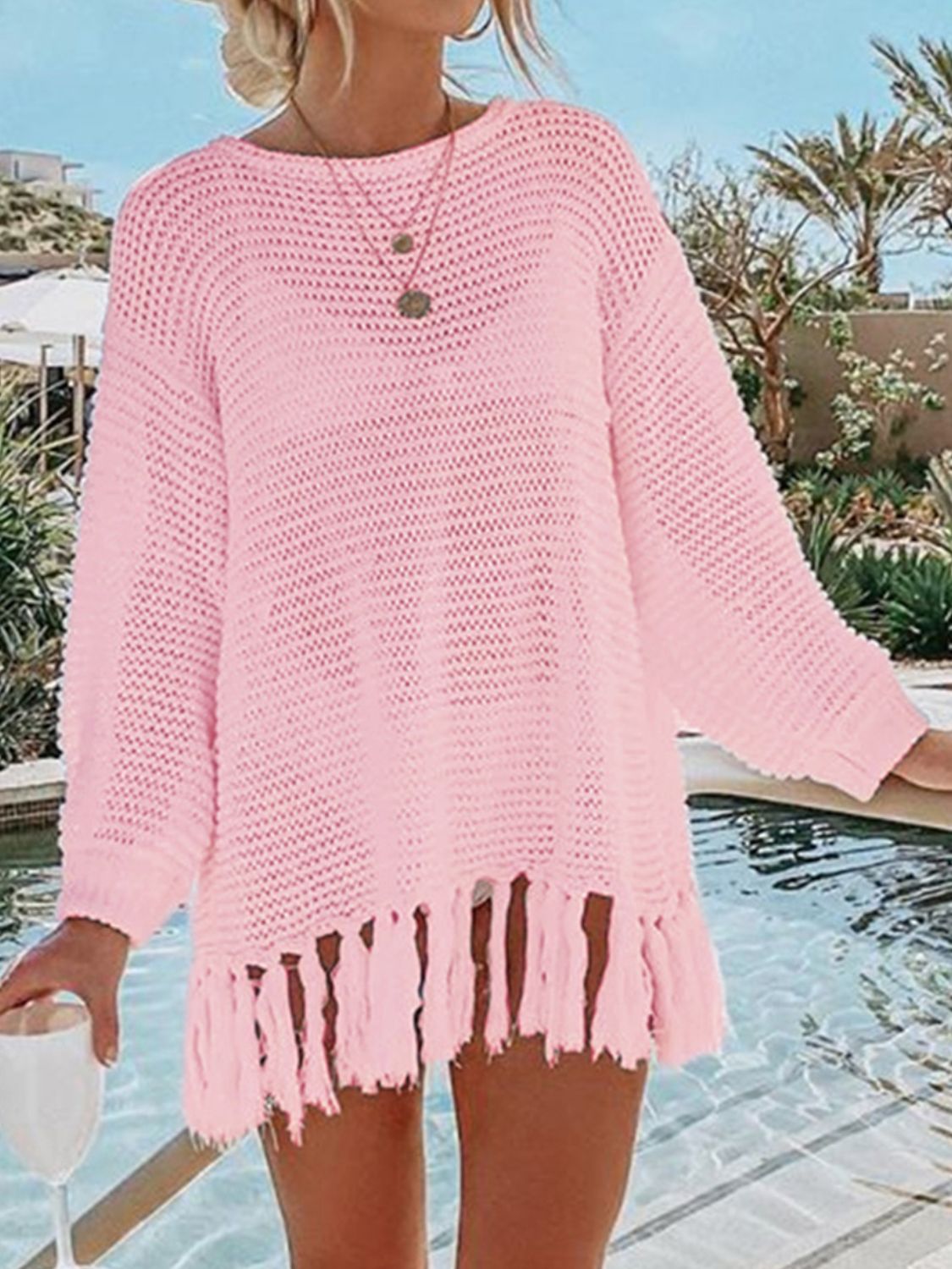 Blush pink open-knit acrylic beach cover-up with fringe hem and crew neck.