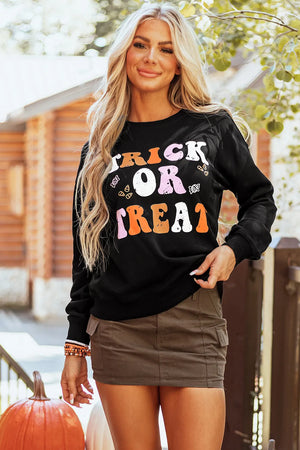 Black crewneck sweatshirt with colorful "Trick or Treat" graphic and candy motifs.