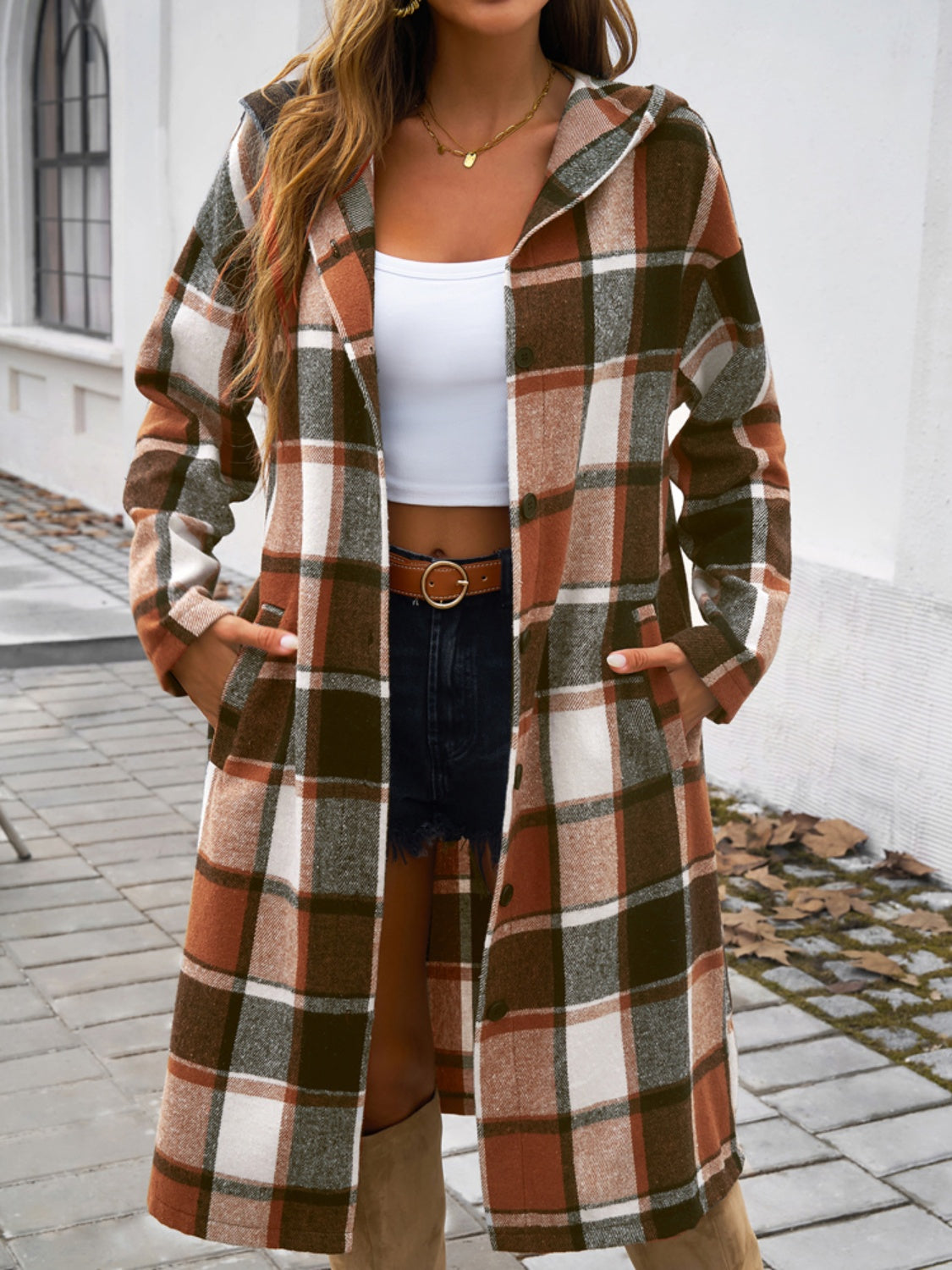 Checked plaid hooded duster coat in brown with buttoned front and pockets.