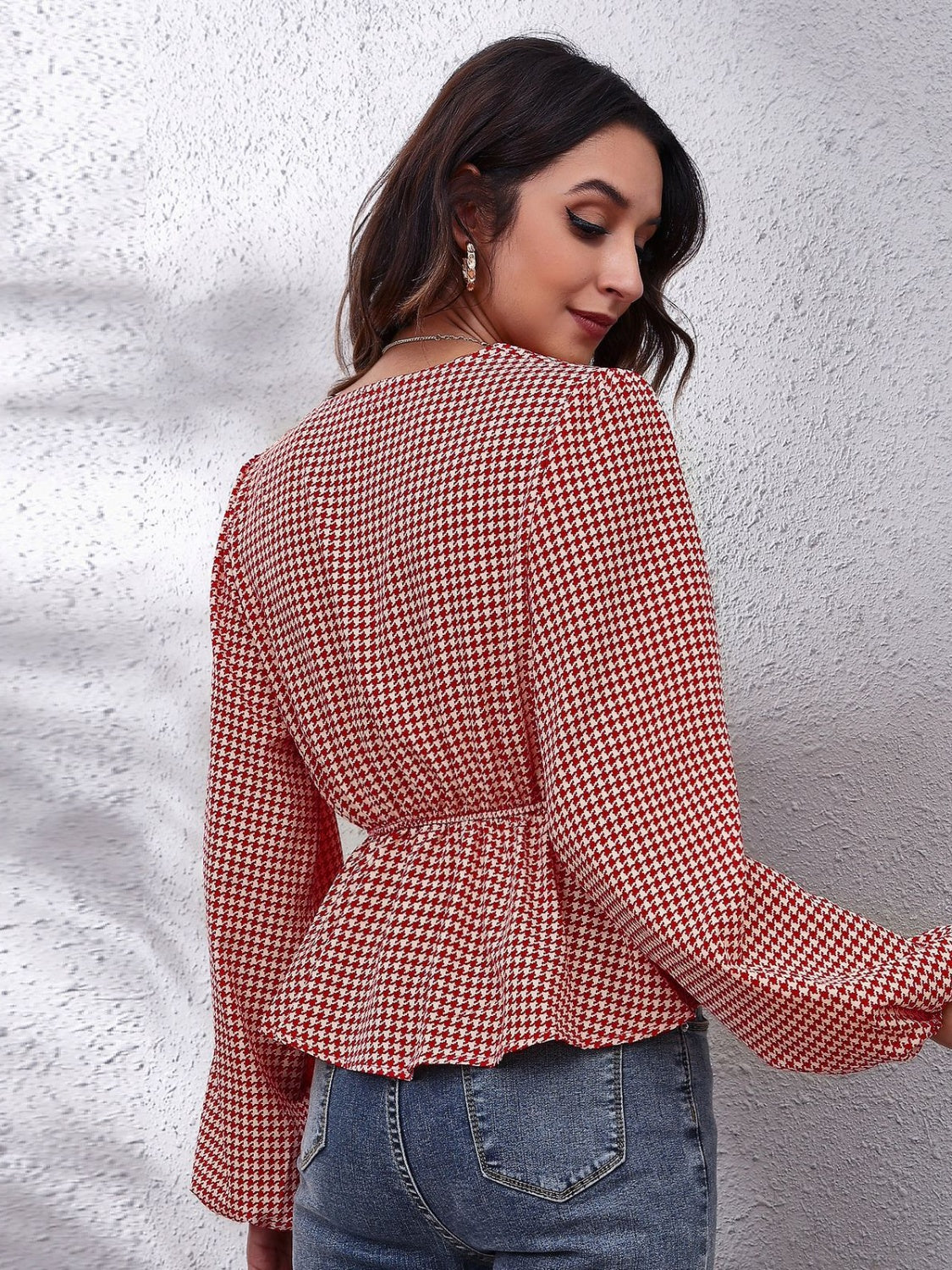 Red and white houndstooth peplum blouse with gathered waist and bell sleeves.