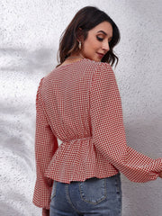 Red and white houndstooth peplum blouse with gathered waist and bell sleeves.