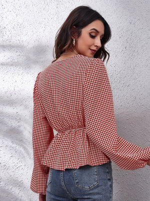 Red and white houndstooth peplum blouse with gathered waist and bell sleeves.