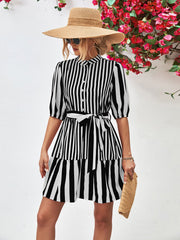 Black and white striped shirred waist dress with tiered hem and tie belt.