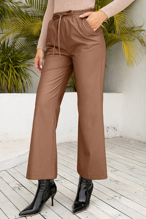 Caramel wide-leg drawstring pants with pockets, styled with black patent boots.