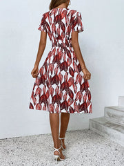 Red leaf pattern midi dress with smocked waist and short sleeves.
