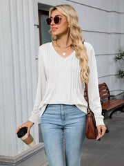 White V-neck long sleeve t-shirt with subtle pintuck detail, paired with jeans.
