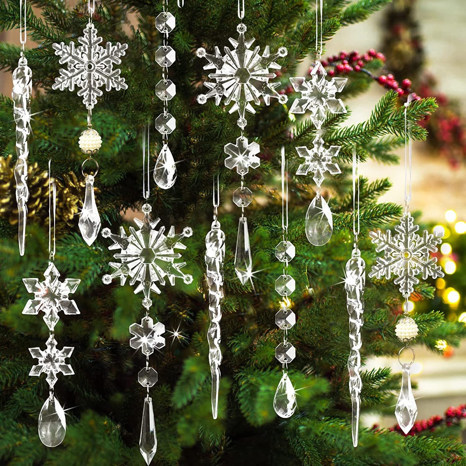 Transparent acrylic icicle and snowflake Christmas ornaments hang on a tree.