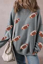 Dark gray sweatshirt with allover football sequin embellishments and a crew neckline.