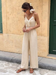 Cream lace-trimmed spaghetti strap romper with wide legs and cutout detail.