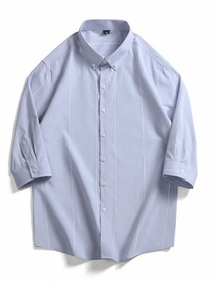Light blue cotton oversized button-down shirt with white vertical stripes and buttoned cuffs.