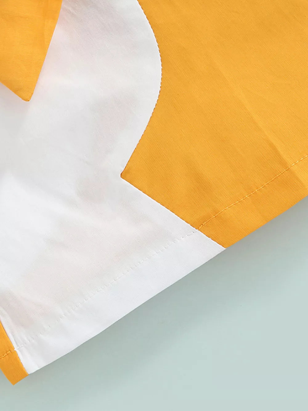 Two-piece knit set in yellow and white with a scalloped detail.