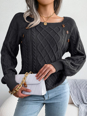 Charcoal cable-knit sweater with buttoned shoulder detail and balloon sleeves.