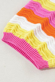 Colorblock knit sweater with pink, yellow, white, and orange wavy stripes and puff sleeves.