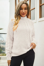 Beige cable-knit turtleneck sweater with voluminous silhouette and textured acrylic knit.