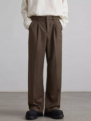 Brown pleated wide-leg trousers with a relaxed fit, styled casually.