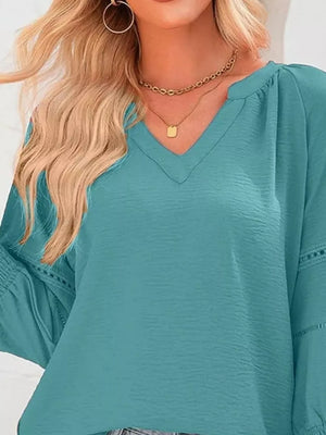 Elegant smocked long sleeve blouse in Lake Green polyester with V-neck and textured fabric.