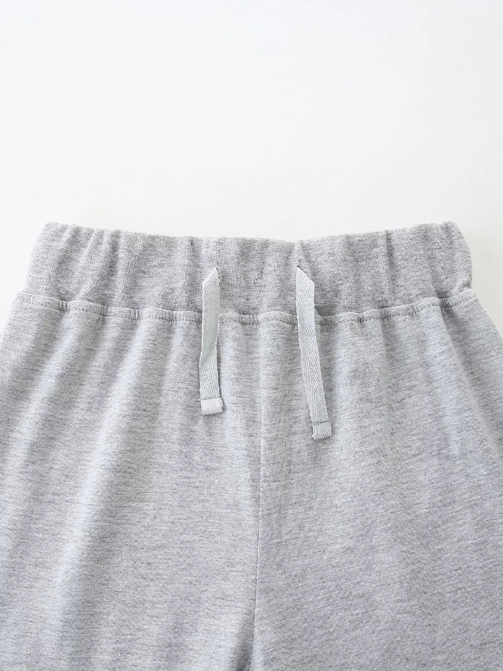 Grey cotton blend baby shorts with elastic waistband and drawstring.