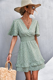 Gum Leaf smocked waist mini dress with flutter sleeves and ruffle hem, featuring a white speckle print.