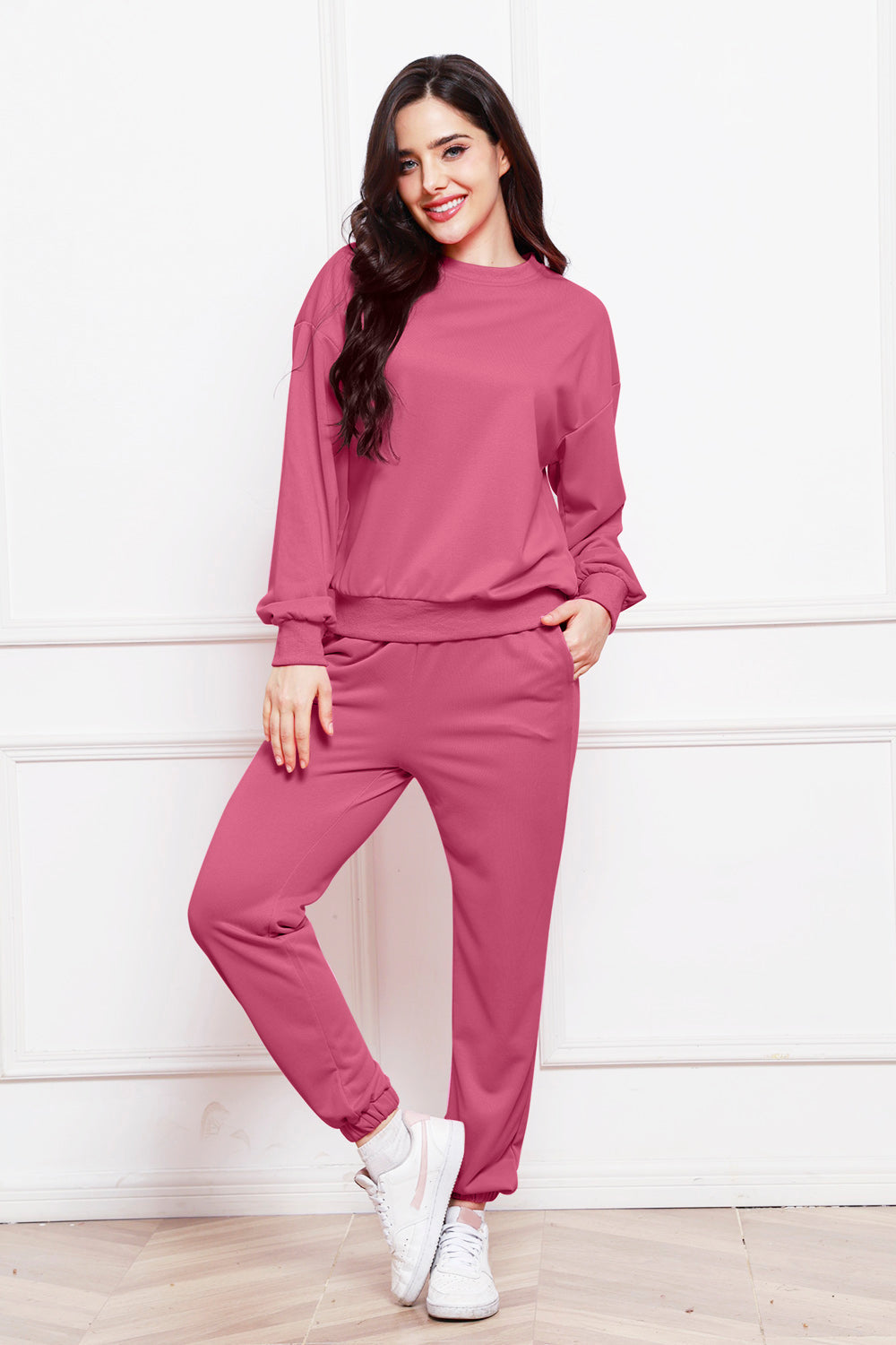 Relaxed fit loungewear set in hot pink, featuring a crewneck sweatshirt and matching joggers with cuffed ankles.