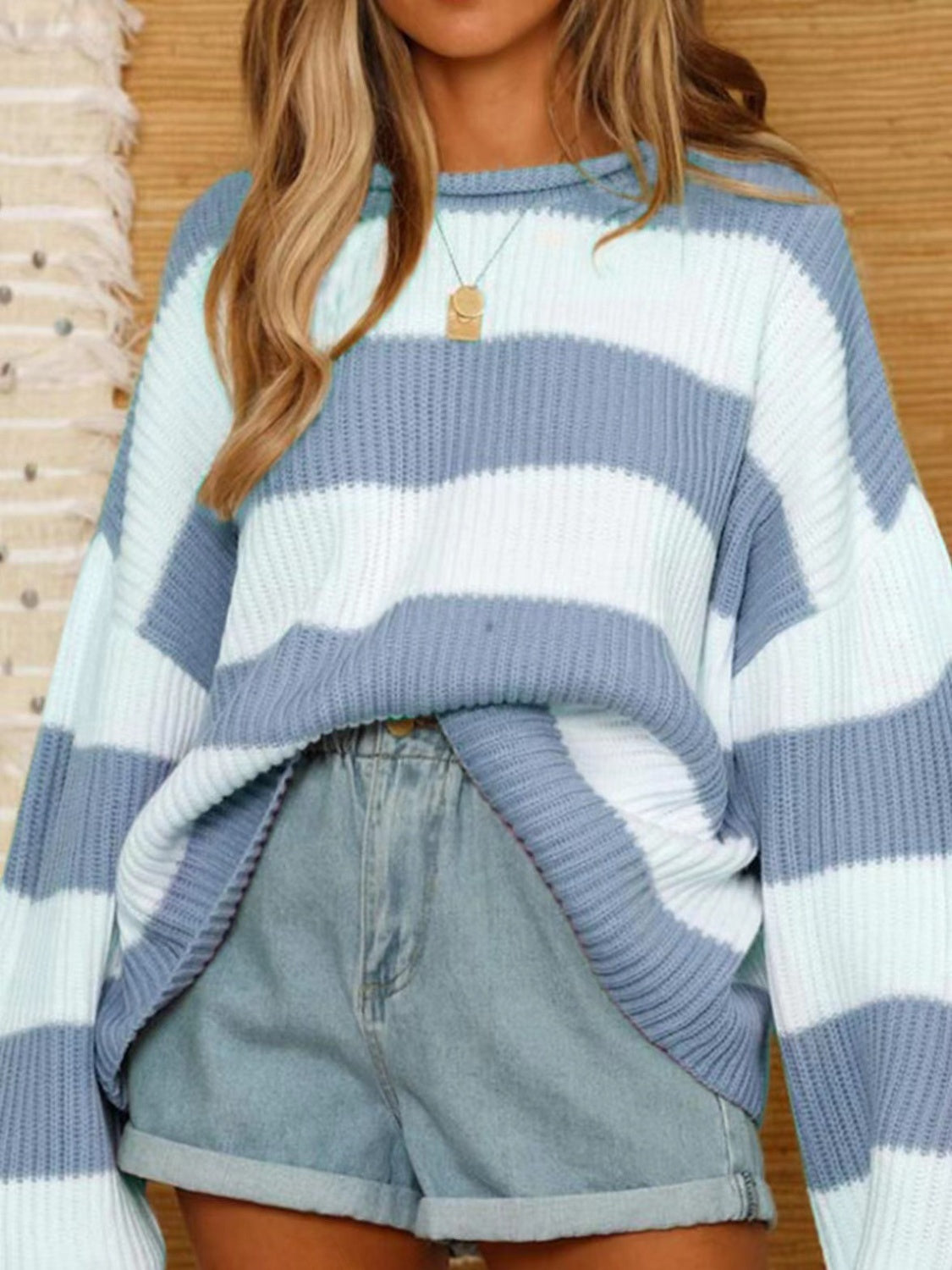 Striped oversized knit sweater in blue and white with a crew neck.