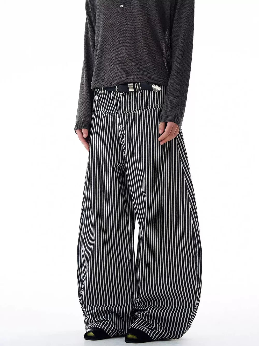 Men's black and white striped wide-leg sweatpants with a black belt.