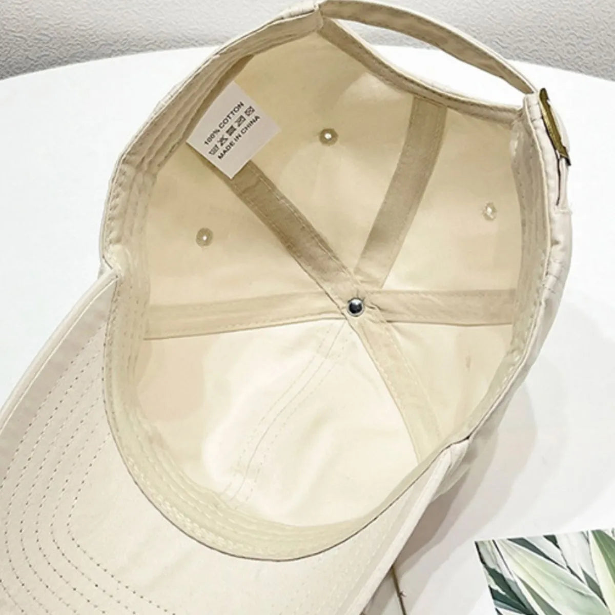 Cream baseball cap interior with 100% cotton tag and adjustable strap