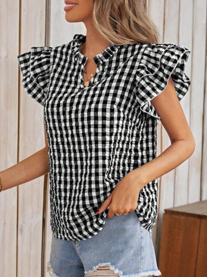 Black and white gingham blouse with ruffle sleeves and a mock neckline.