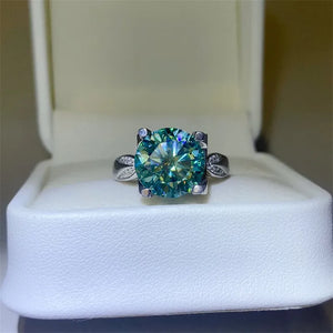 Silver ring with large green moissanite solitaire and pavé accents.