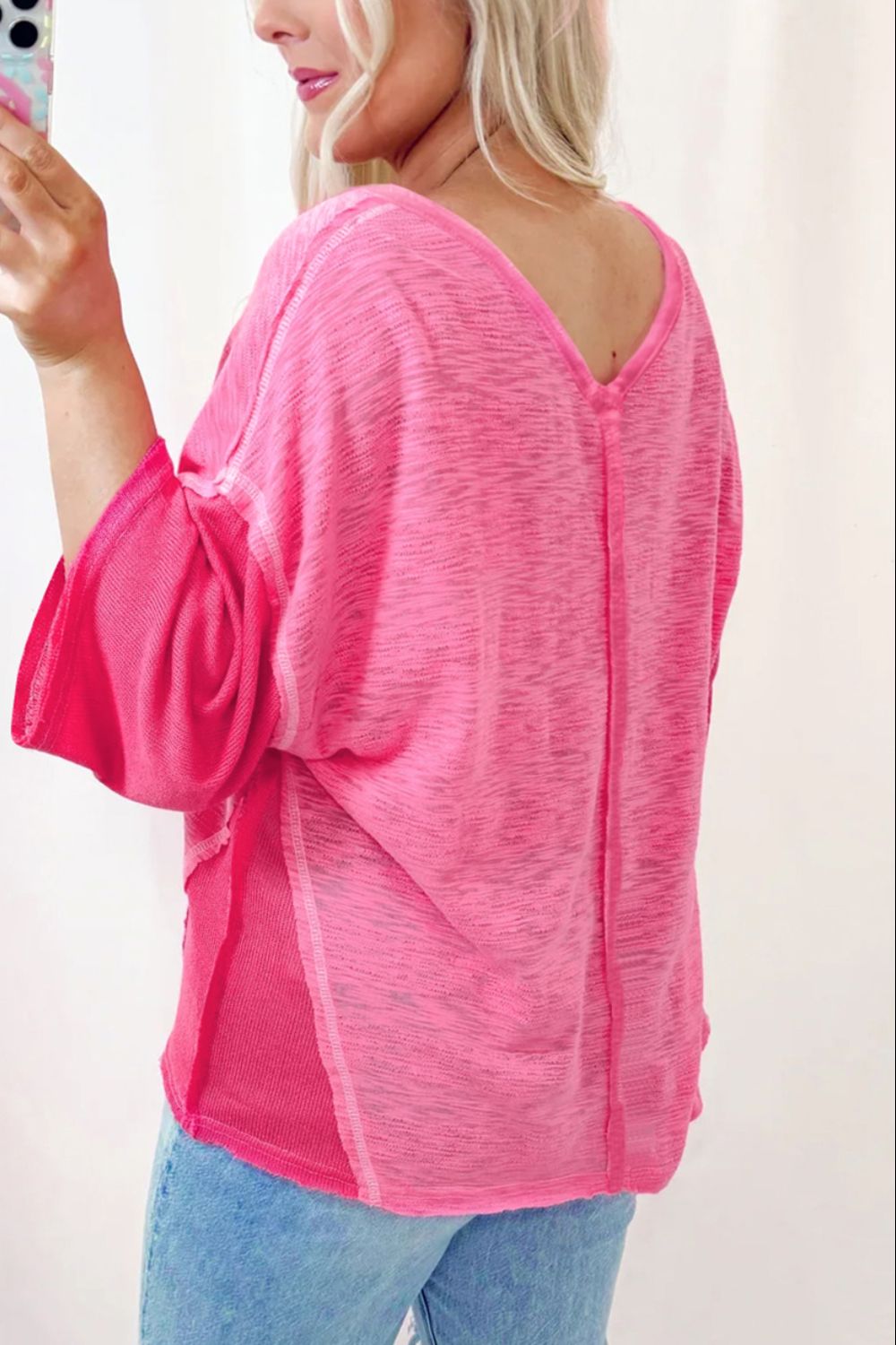 Hot pink v-neck blouse with contrast panels and wide sleeves.