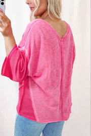 Hot pink v-neck blouse with contrast panels and wide sleeves.