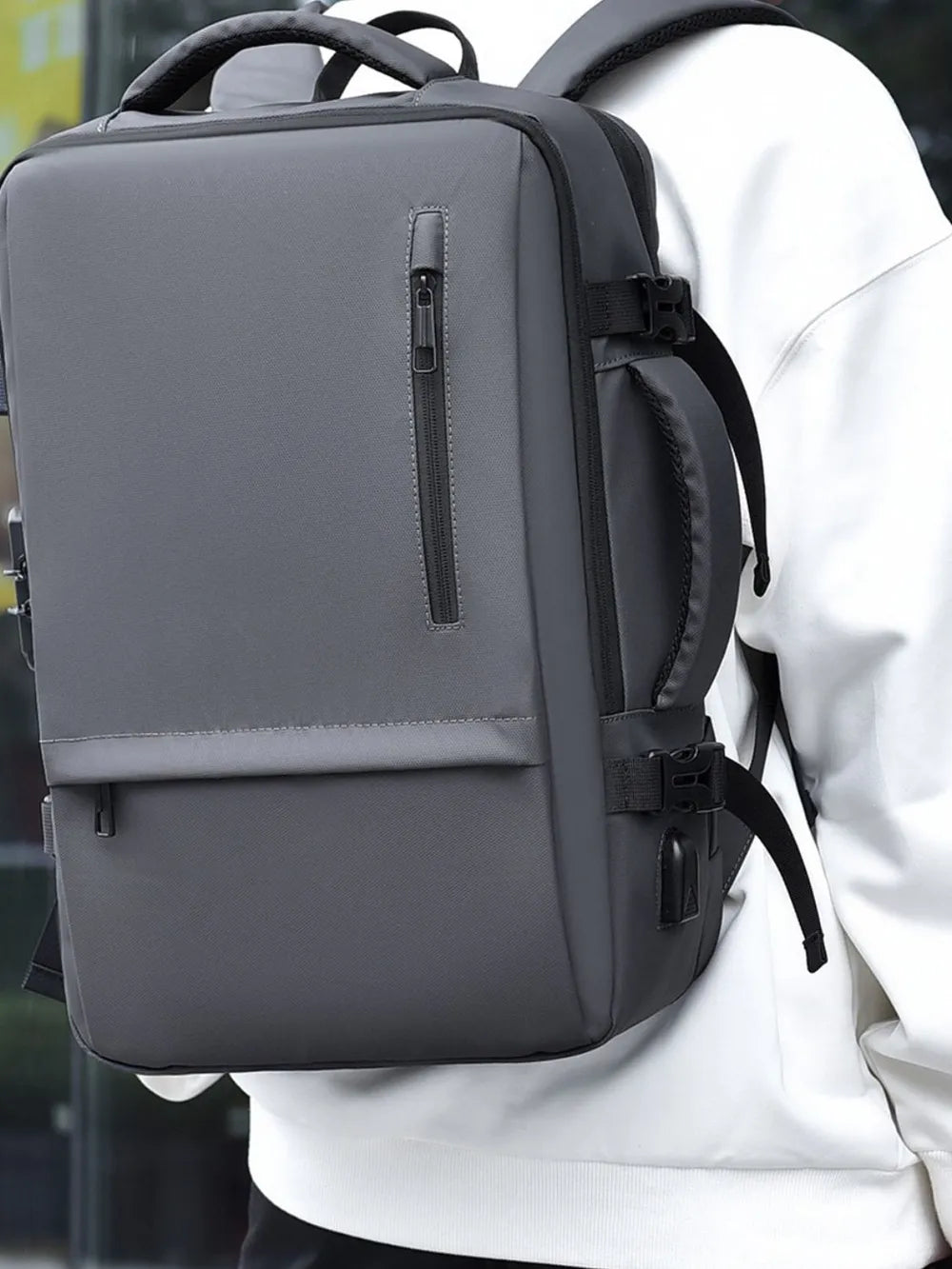 Dark gray convertible commuter backpack with multiple zippered pockets and a side USB port.