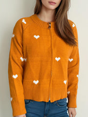 Orange zip-through knit cardigan with white heart pattern and ribbed cuffs.