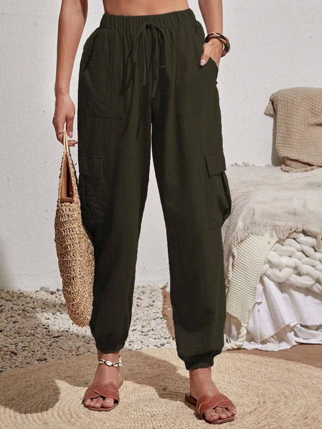 Dark green textured cargo lounge trousers with drawstring waist and cuffed ankles.