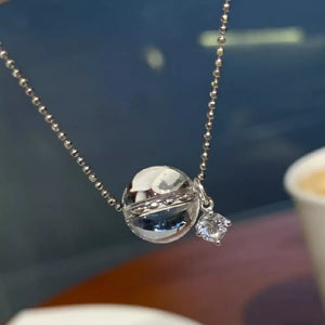 Luminous crystal pendant necklace in silver with a clear orb and diamond accent.