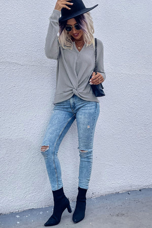 Gray waffle knit sweater with a knot front detail and v-neck.