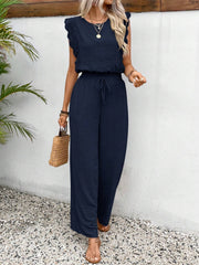Dark blue textured ruffle sleeve drawstring jumpsuit with wide leg pants.