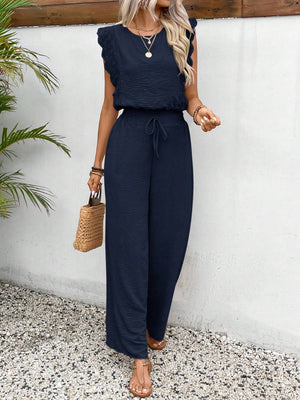 Dark blue textured ruffle sleeve drawstring jumpsuit with wide leg pants.