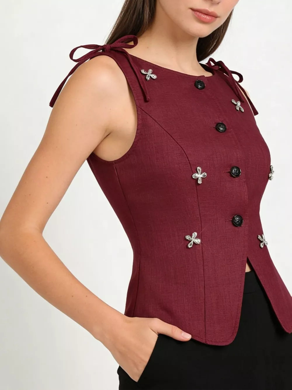 Burgundy tie-shoulder vest with button front and floral appliqu detail.