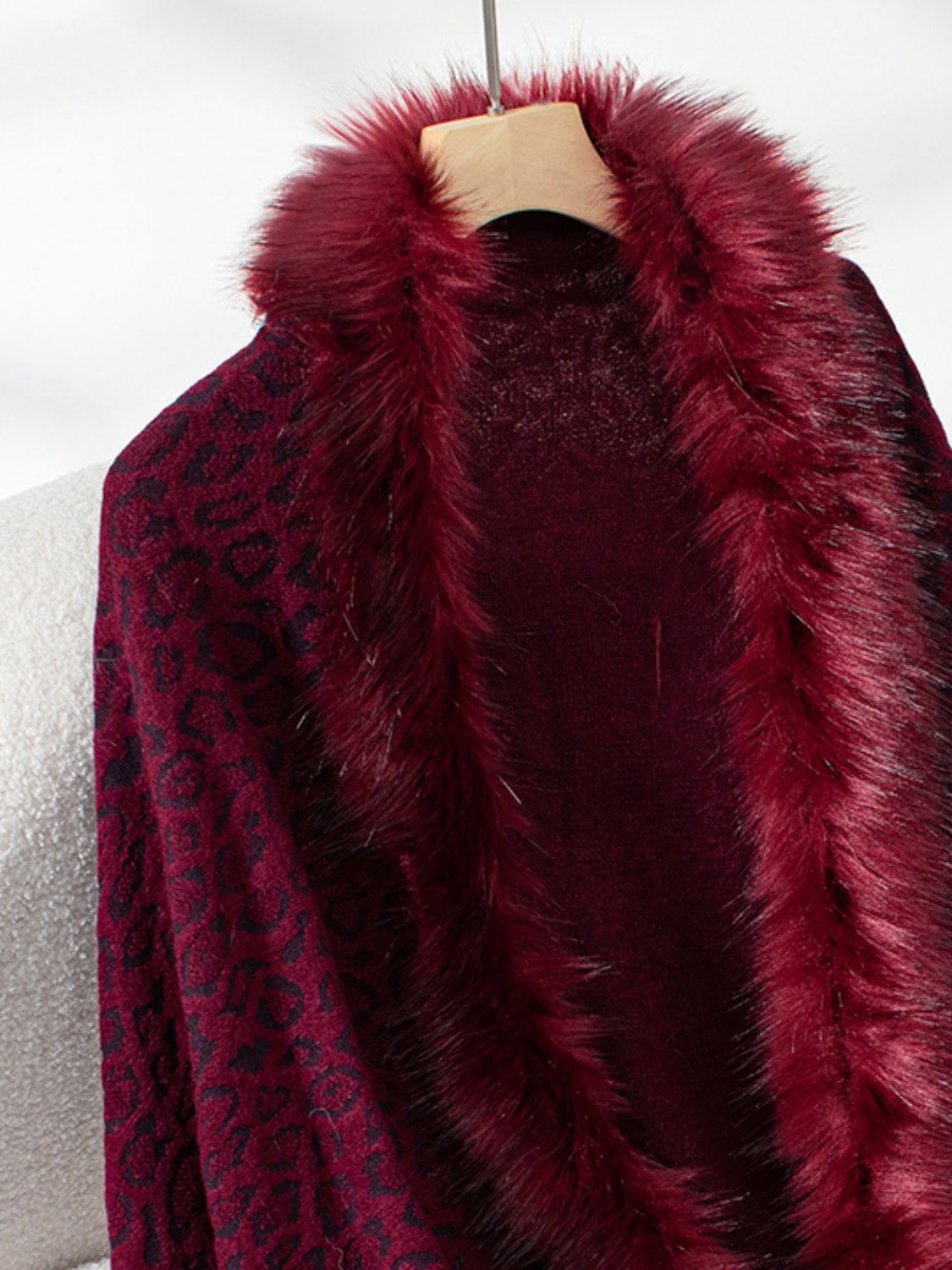 Burgundy leopard print cardigan with plush faux fur trim detail.